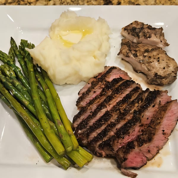 Sliced BBQ steak, mashed potatoes with butter, grilled asparagus, and mushrooms on a white plate.